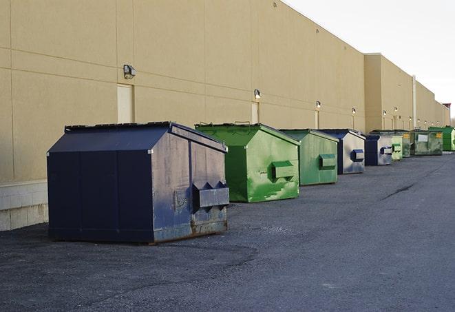 a crowd of dumpsters of all colors and sizes at a construction site in Coweta